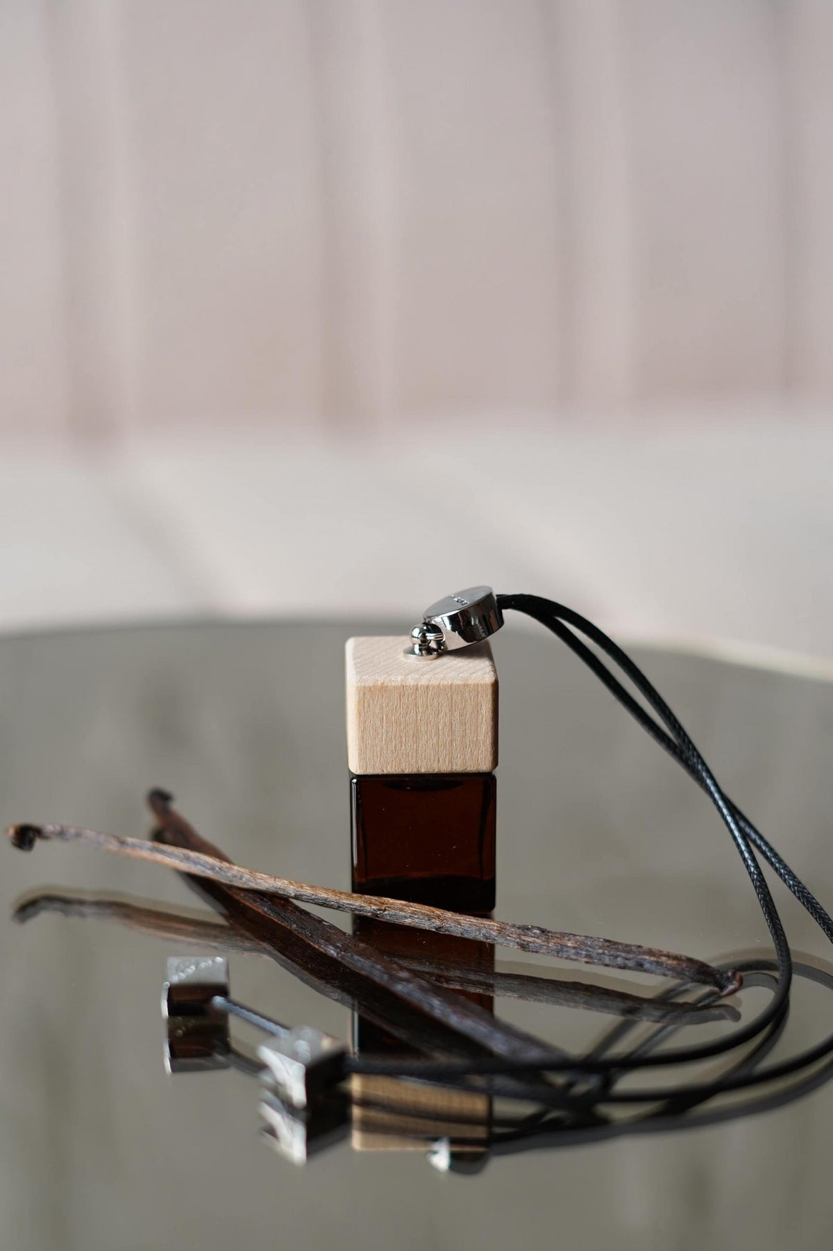 Άρωμα αυτοκινήτου Tobacco Vanilla BY VELCHEVA 10ml σε γυάλινο μπουκάλι amber με ξύλινο καπάκι και μαύρο κορδόνι, δίπλα σε λοβούς βανίλιας