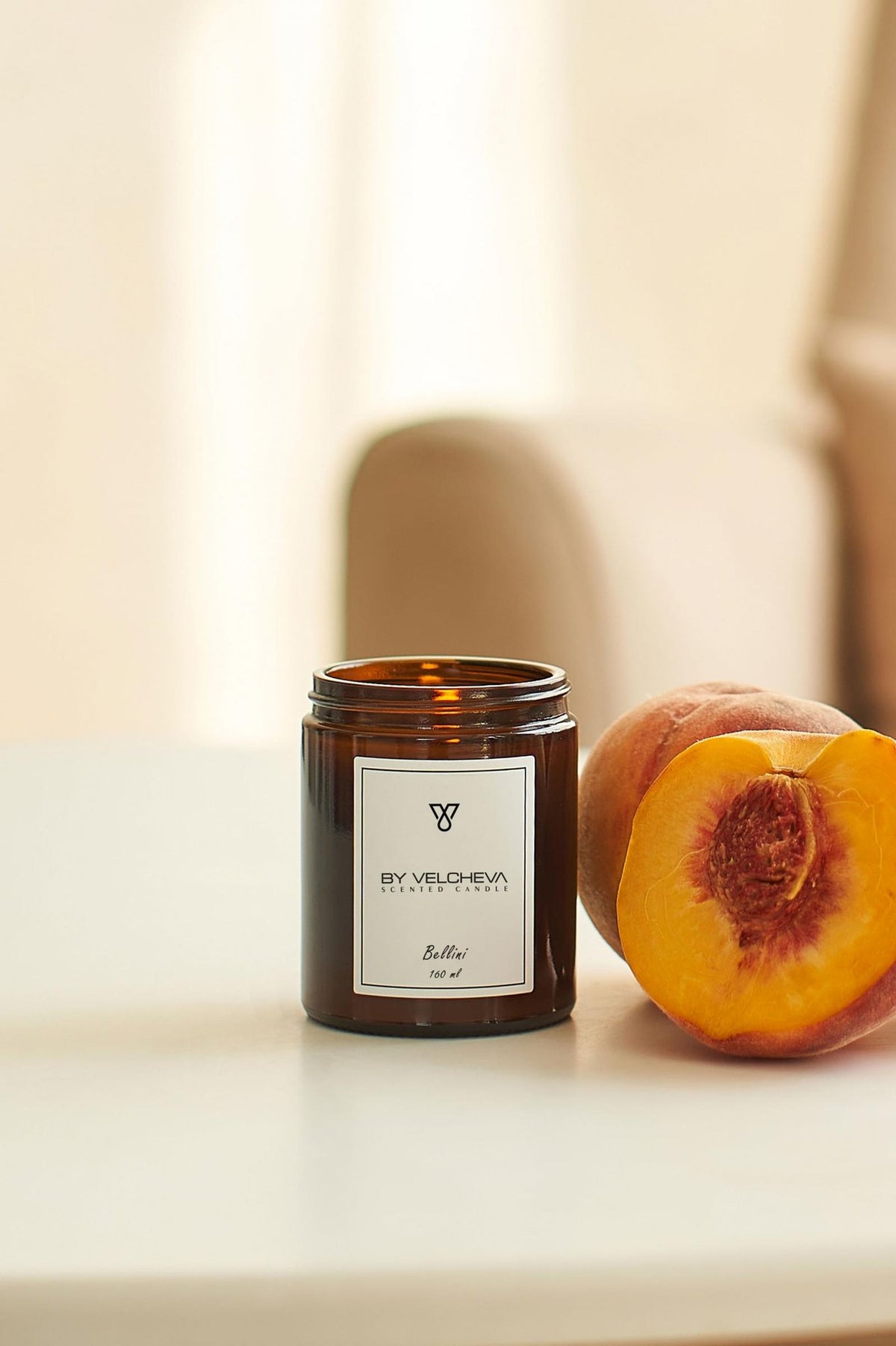 Αρωματικό κερί Bellini BY VELCHEVA 160ml σε γυάλινο βάζο amber, με ολόκληρο και μισό ροδάκινο σε φωτεινό φόντο