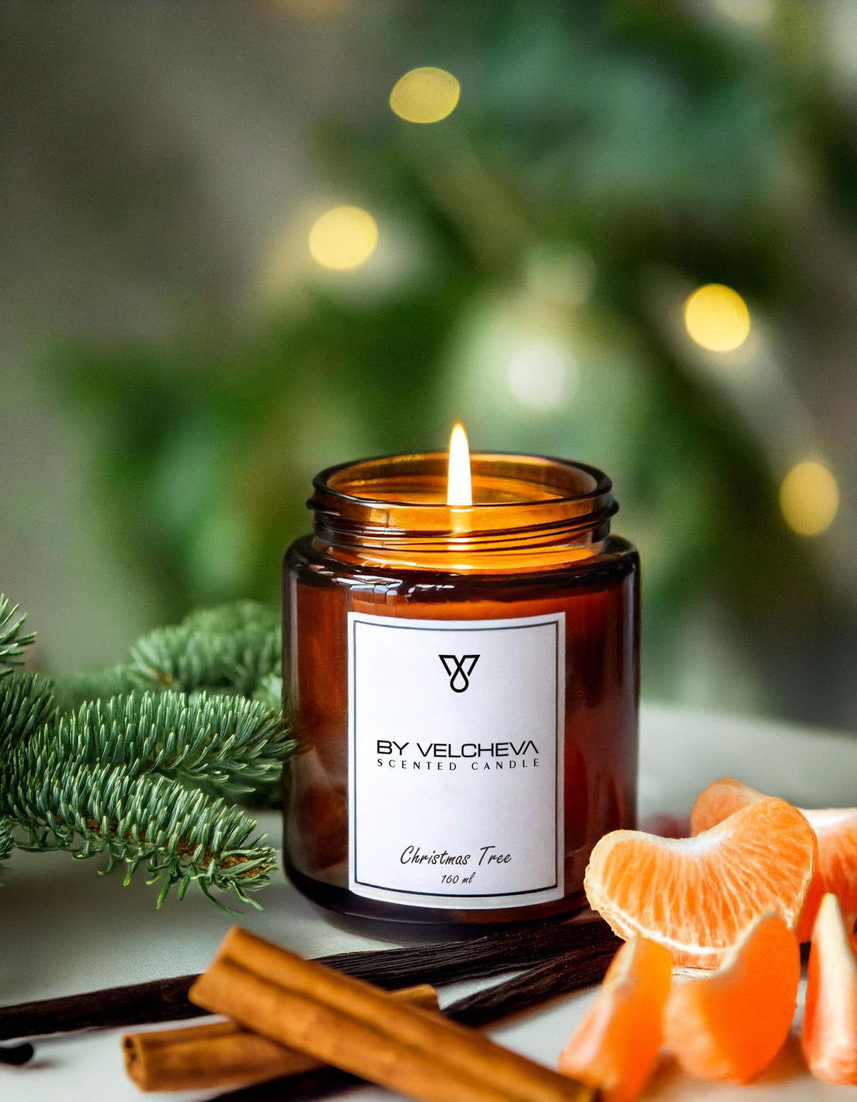 Αρωματικό κερί Christmas Tree BY VELCHEVA 160ml σε γυάλινο βάζο amber, αναμμένο, με κλαδί έλατου, κανέλα και μανταρίνι