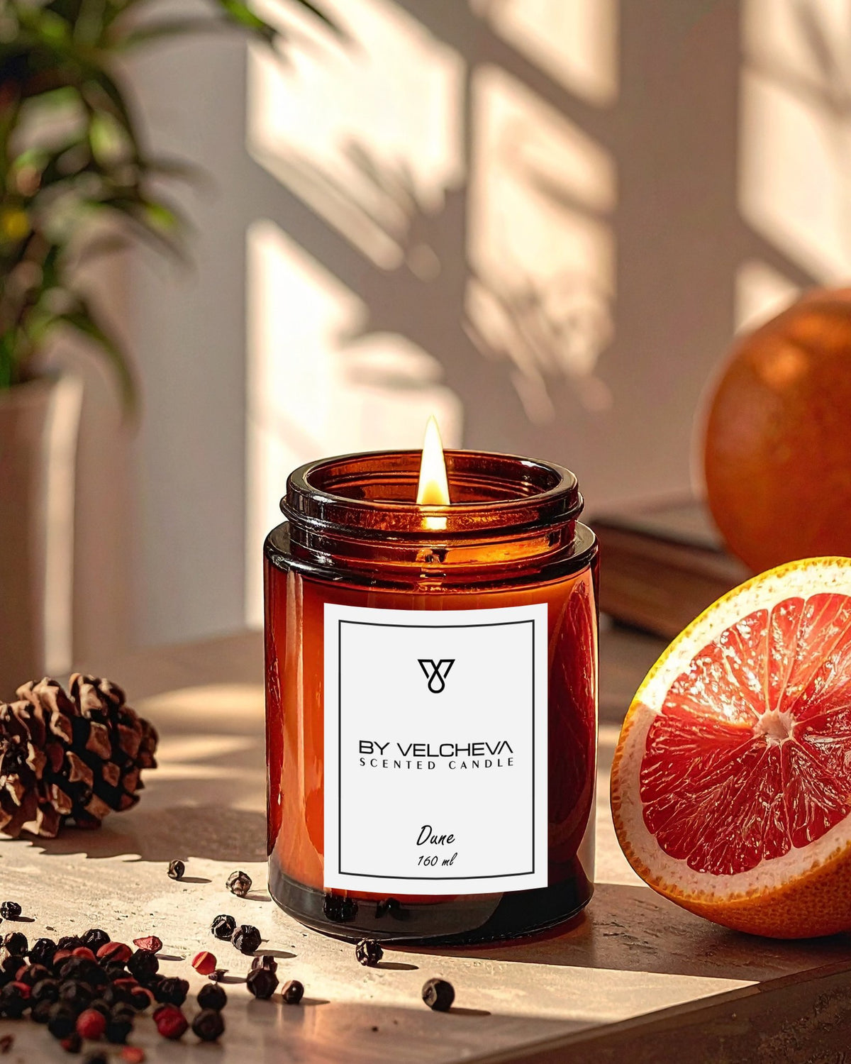 Αρωματικό κερί Dune BY VELCHEVA 160ml σε γυάλινο βάζο amber, αναμμένο, με γκρέιπφρουτ, πορτοκάλι και κόκκους πιπεριού σε φωτεινό φόντο